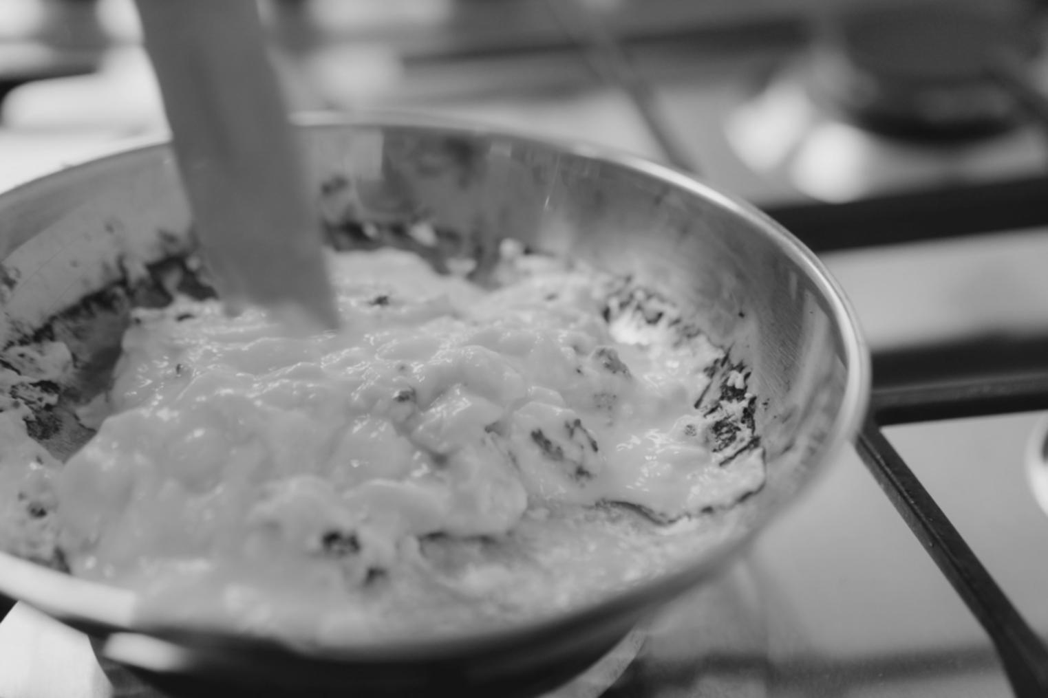 Chef demonstrating traditional cooking method in authentic kitchen setting
